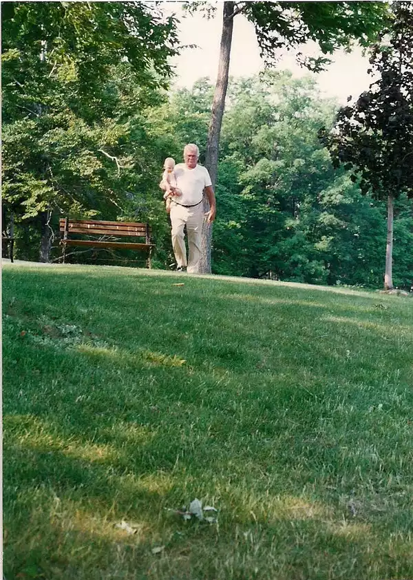 1992-Joe Meyer Sr carrying Joe Meyer III in front of Loon Lake house